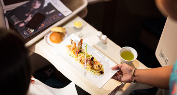 An air hostess serving a meal to a passenger